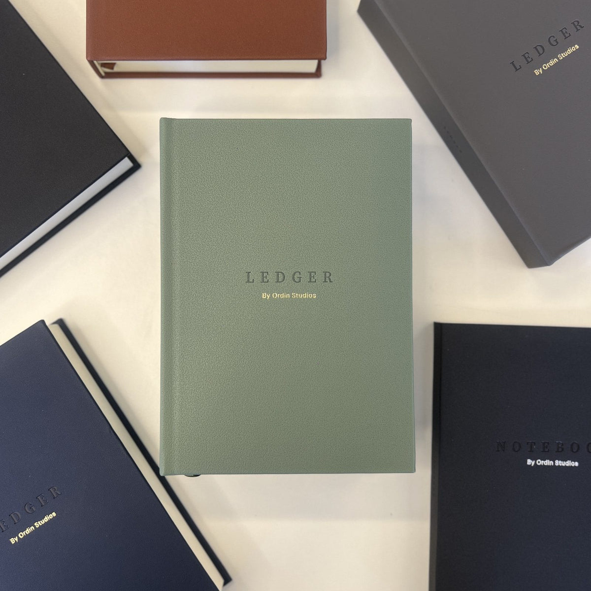 The Ledger in Forest Green, flat-lay among the collection